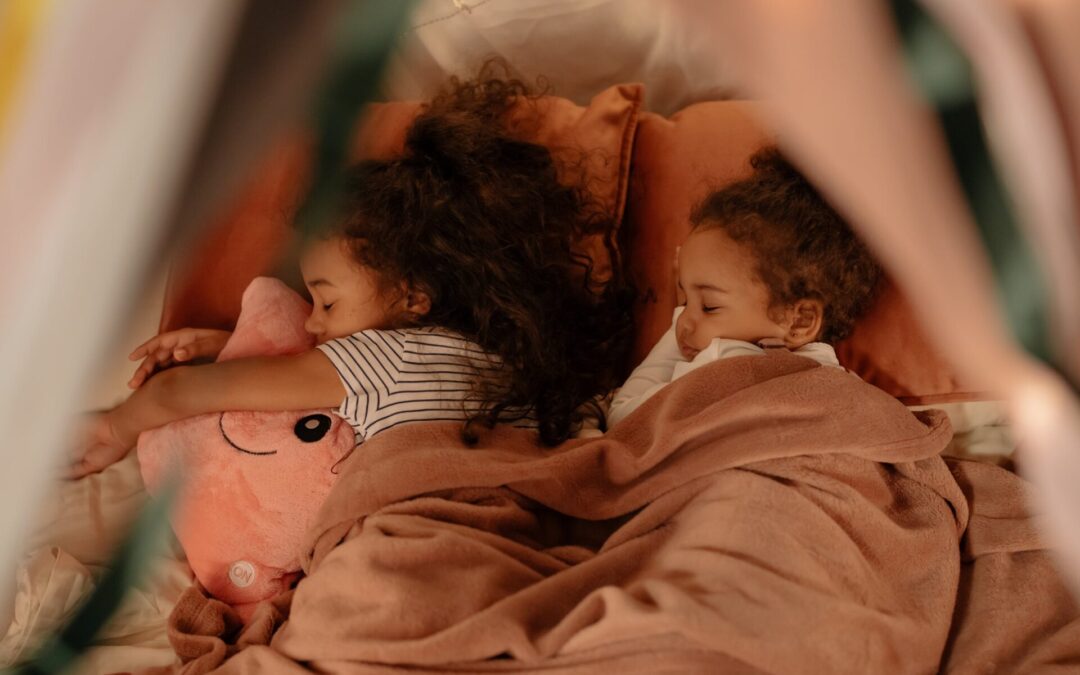 Two young girls fast asleep in bed.