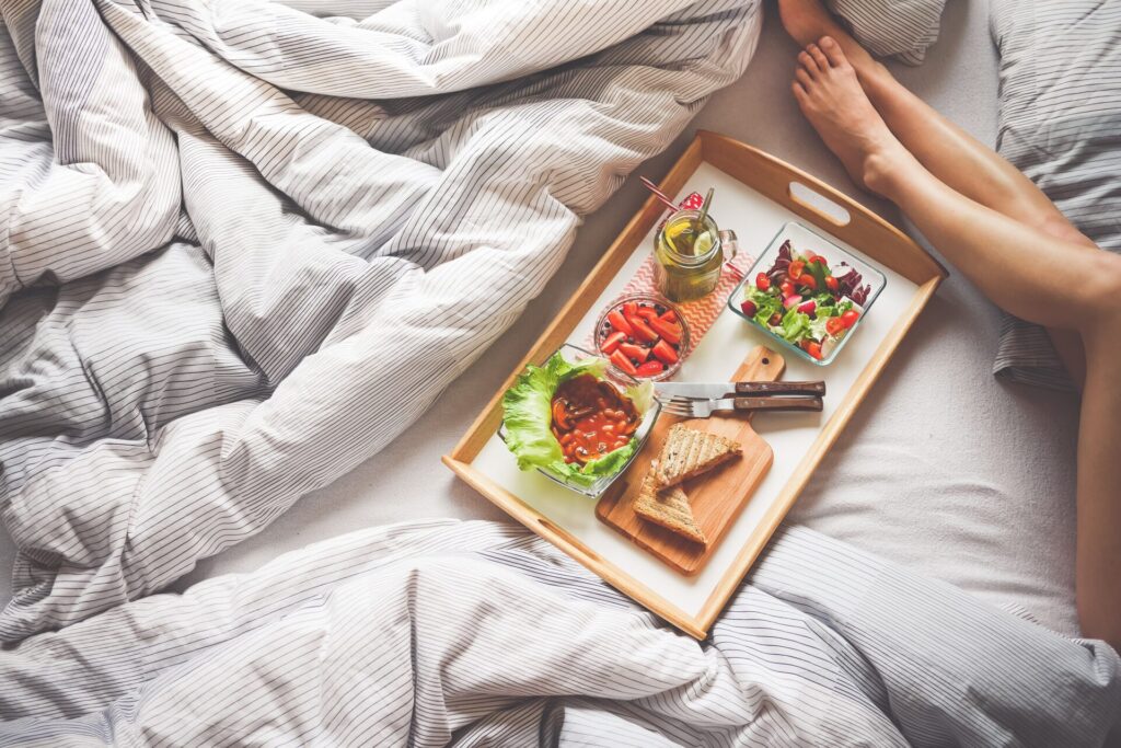 Breakfast tray on a bed.  Contains toast