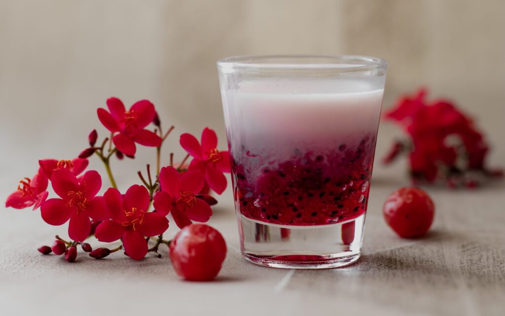 Tart cherry juice in a glass surrounded by cherries